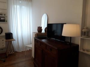 salon z telewizorem na komodzie z lampką w obiekcie "Authentique" - STAYHOME - appart 4 w mieście Quimper +5 zdjęć