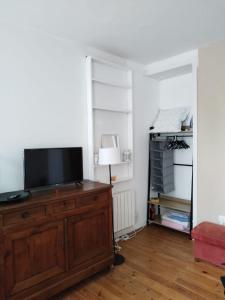 salon z telewizorem na drewnianej komodzie w obiekcie "Authentique" - STAYHOME - appart 4 w mieście Quimper