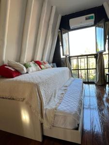 sypialnia z łóżkiem z białą pościelą i czerwonymi poduszkami w obiekcie Chacras House w mieście Lujan de Cuyo