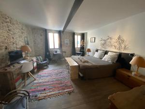 a bedroom with a bed and a desk and a television at Pitibi Maison d'Hote in Sanary-sur-Mer