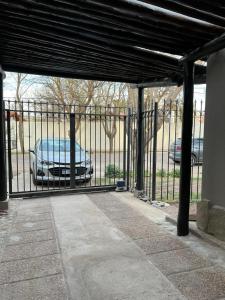 Una puerta negra con un coche aparcado detrás. en Chacras House en Luján de Cuyo
