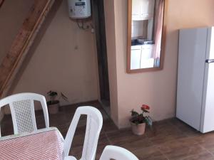 a dining room with white chairs and a table and a mirror at Macrigaluma Luna solo con seña in Barra del Chuy