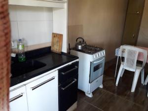 a small kitchen with a stove and a sink at Macrigaluma Luna in Barra del Chuy