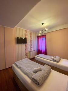 um quarto com 2 camas e uma janela cor-de-rosa em Prenociste Lane em Ključ