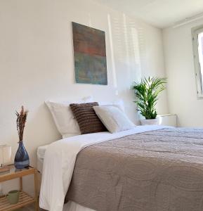 1 dormitorio con 1 cama y una pintura en la pared en La Voulzie Appartement - Proche centre avec parking privé, en Provins