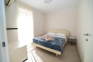 a small bedroom with a bed with a blue blanket at VILLA LEVANTE - Beach & Jacuzzi in Torre Santa Sabina