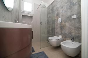 a bathroom with a toilet and a sink and a shower at VILLA LEVANTE - Beach & Jacuzzi in Torre Santa Sabina