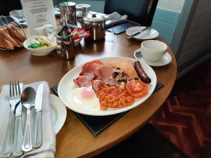 a plate of breakfast food on a wooden table at Hen Dy in Llandudno