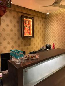 a restaurant with a counter with glasses on it at Hotel Shivanand in Siliguri
