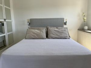 1 dormitorio con 1 cama grande con sábanas y almohadas blancas en Recoleta Apartment en Buenos Aires