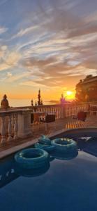 una piscina con puesta de sol en el fondo en Ashram Villa Sunshine, en Sitges