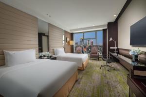 a hotel room with two beds and a television at Holiday Inn Beijing Focus Square by IHG in Beijing