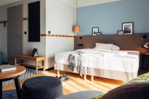 1 dormitorio con 1 cama grande y 1 mesa en harry's home hotel & apartments, en Villach