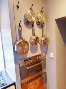 a bunch of pots and pans hanging above an oven at Pentland Farm House in Kirknewton