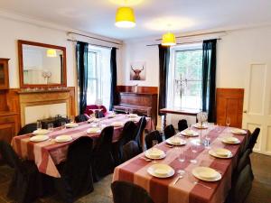a room with a long table with chairs and a piano at Pentland Farm House in Kirknewton