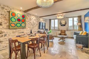 a dining room with a table and chairs and a living room at Appartement Garance in Nîmes