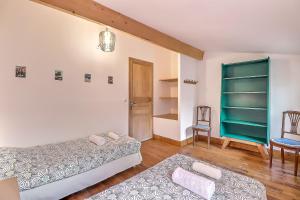 a living room with two beds and a chair at Appartement Garance in Nîmes