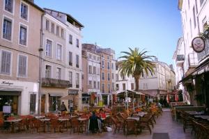 a street with tables and chairs and people sitting at tables at Appartement Garance in Nîmes