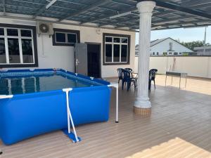 uma piscina com uma mesa e cadeiras num pátio em homestay port dickson - elaine em Porto Dickson