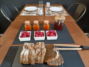 a table with bread and jars of honey and raspberries at BB LETTERARIO in Ravenna