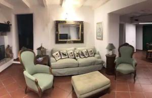 ein Wohnzimmer mit einem Sofa, Stühlen und einem Spiegel in der Unterkunft “SPArisio” CASA IN SASSO CON PISCINA E CAMPO DA TENNIS in Lama