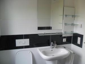 ein Bad mit einem Waschbecken und einem Spiegel in der Unterkunft Apartment Suda in Rheinhausen