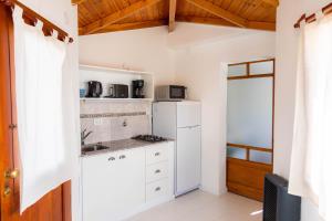uma cozinha com armários brancos e um frigorífico branco em Mamma, Esquel. em Esquel