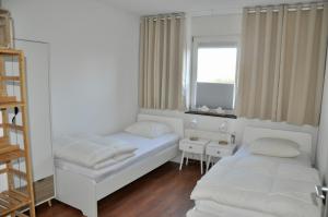 ein kleines Zimmer mit 2 Betten und einem Fenster in der Unterkunft Duinerei appartement C001 in Callantsoog