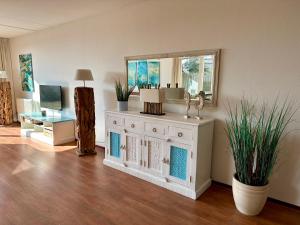 ein Wohnzimmer mit einem Spiegel und einer Kommode in der Unterkunft Duinerei appartement C001 in Callantsoog