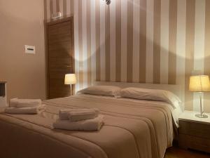 a bedroom with a large bed with towels on it at La Valle degli Ulivi in Acquedolci