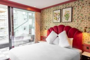 a bedroom with a large bed with a red headboard at The Dean Dublin in Dublin