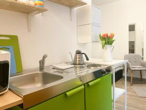 a kitchen with a sink and a vase of flowers at Ferienzimmer Adalonia in Greifswald