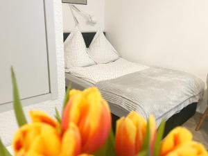 een slaapkamer met een bed en een spiegel en bloemen bij Ferienzimmer Adalonia in Greifswald