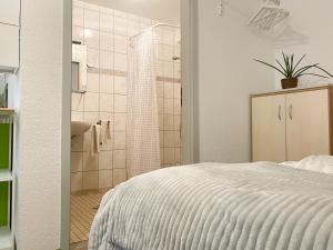 a bedroom with a white bed and a shower at Ferienzimmer Adalonia in Greifswald