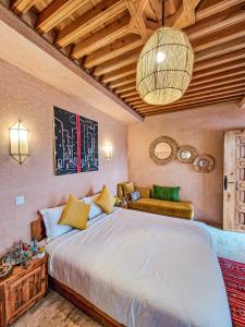 a bedroom with a large bed and a chandelier at Riad El Pacha in Rabat