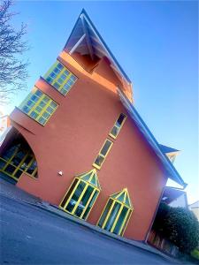 ein rotes Gebäude mit gelben Fenstern an der Seite in der Unterkunft KRYSTALL Hotel in Filderstadt