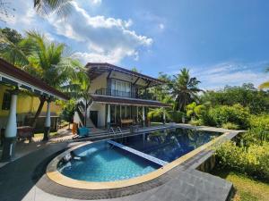 a swimming pool in front of a house at Style Villa in Bentota