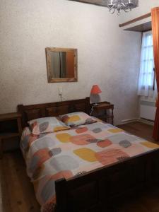 1 dormitorio con cama y espejo en la pared en Canto perdigal, en Caylus