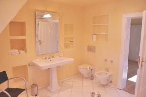 a bathroom with a sink and a toilet and a mirror at Apartment am Bürgerpark in Bremerhaven +19 photos