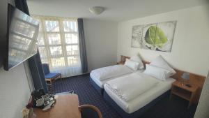 ein Hotelzimmer mit einem Bett und einem Fenster in der Unterkunft KRYSTALL Hotel in Filderstadt