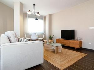 a living room with a white couch and a tv at Charm apartment in Cambados