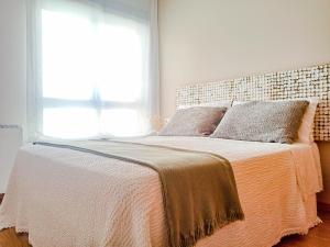 a bedroom with a large bed with a large window at Charm apartment in Cambados