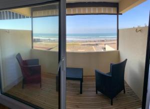 d'un balcon avec deux chaises et une vue sur l'océan. dans l'établissement T2 Rés Océanides vue Océan, parking privé, à Lacanau-Océan