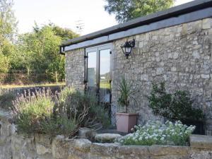 una casa de piedra con una ventana y algunas plantas en Beautiful 3-Bed Cottage in Llancarfan Nr Cardiff, en Barry