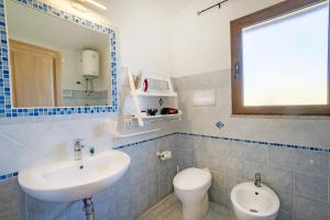 La salle de bains est pourvue d'un lavabo, de toilettes et d'un miroir. dans l'établissement Le Case di Maiorca - PMS CaseVacanze, à Budoni