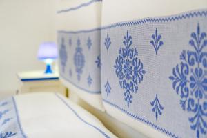 einem nahe gelegenen Bett mit blauer und weißer Bettwäsche in der Unterkunft Le Case di Maiorca - PMS CaseVacanze in Budoni