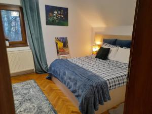 a bedroom with a bed with a blue blanket on it at La Rossa in Braşov