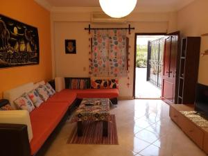 un salon avec un canapé rouge et une table dans l'établissement appartamento casa vacanza, à Charm el-Cheikh