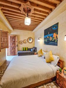 una camera con un grande letto e un divano di Riad El Pacha a Rabat