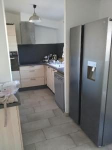 a kitchen with a large stainless steel refrigerator at Adorable maison dans le port in Port-Vendres